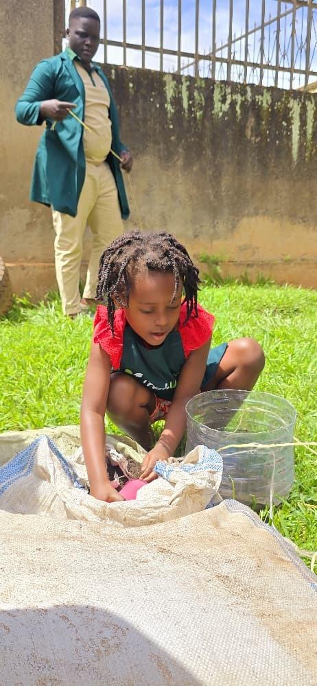 A child planting seeds in a recycled container.